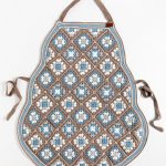 Gehaakte schort van granny squares tegen een witte, neutrale achtergrond.