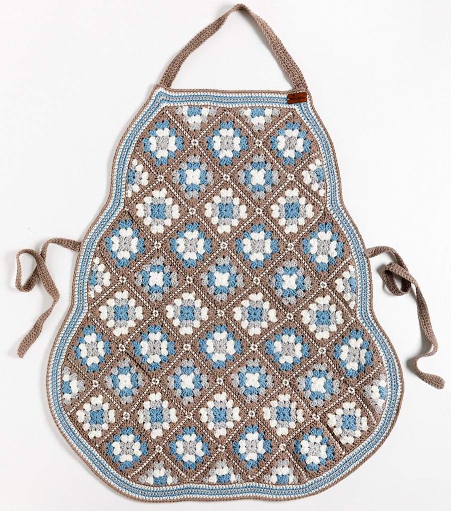 Gehaakte schort van granny squares tegen een witte, neutrale achtergrond.
